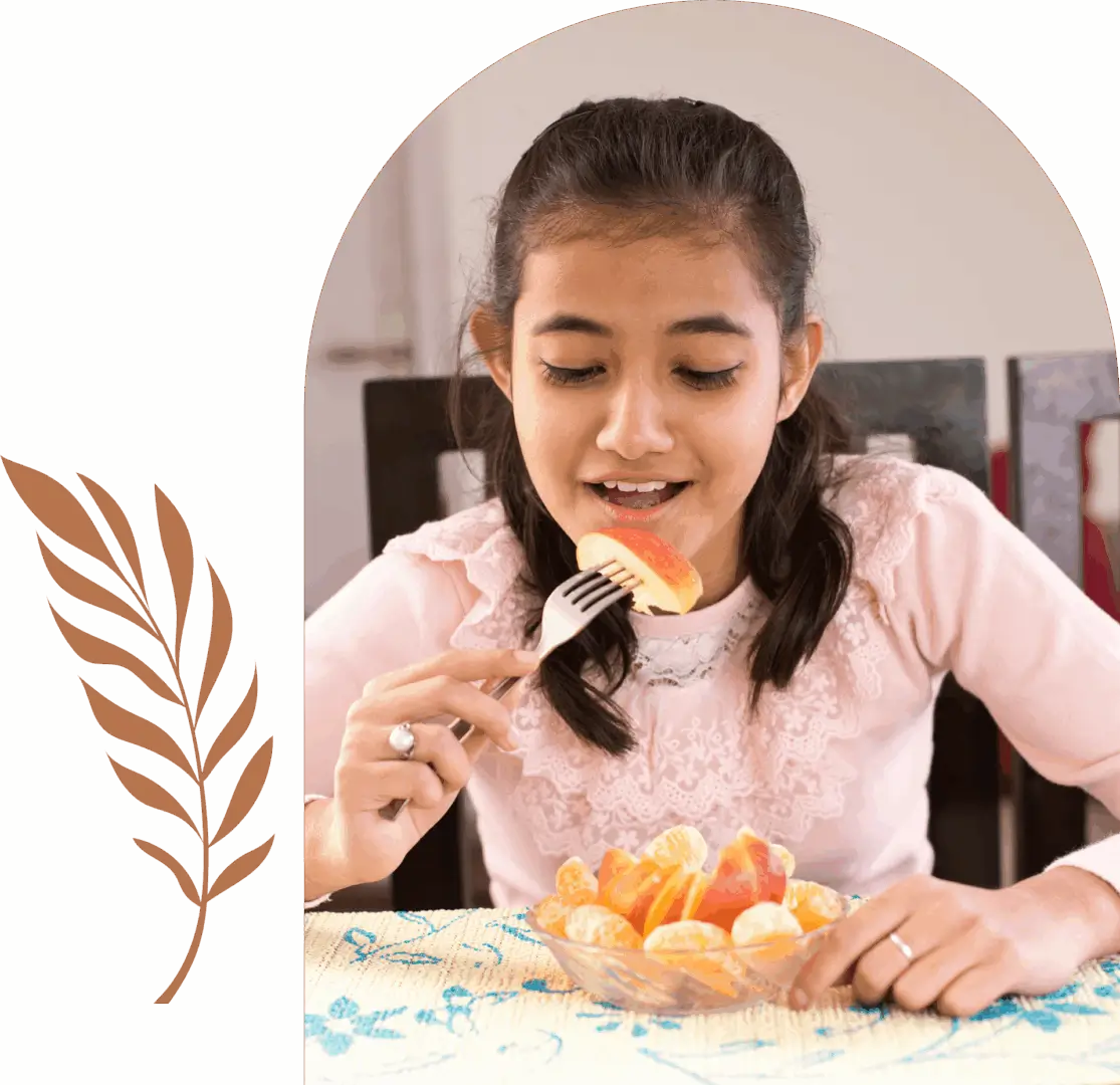 Girl eating sliced fruit with a fork.